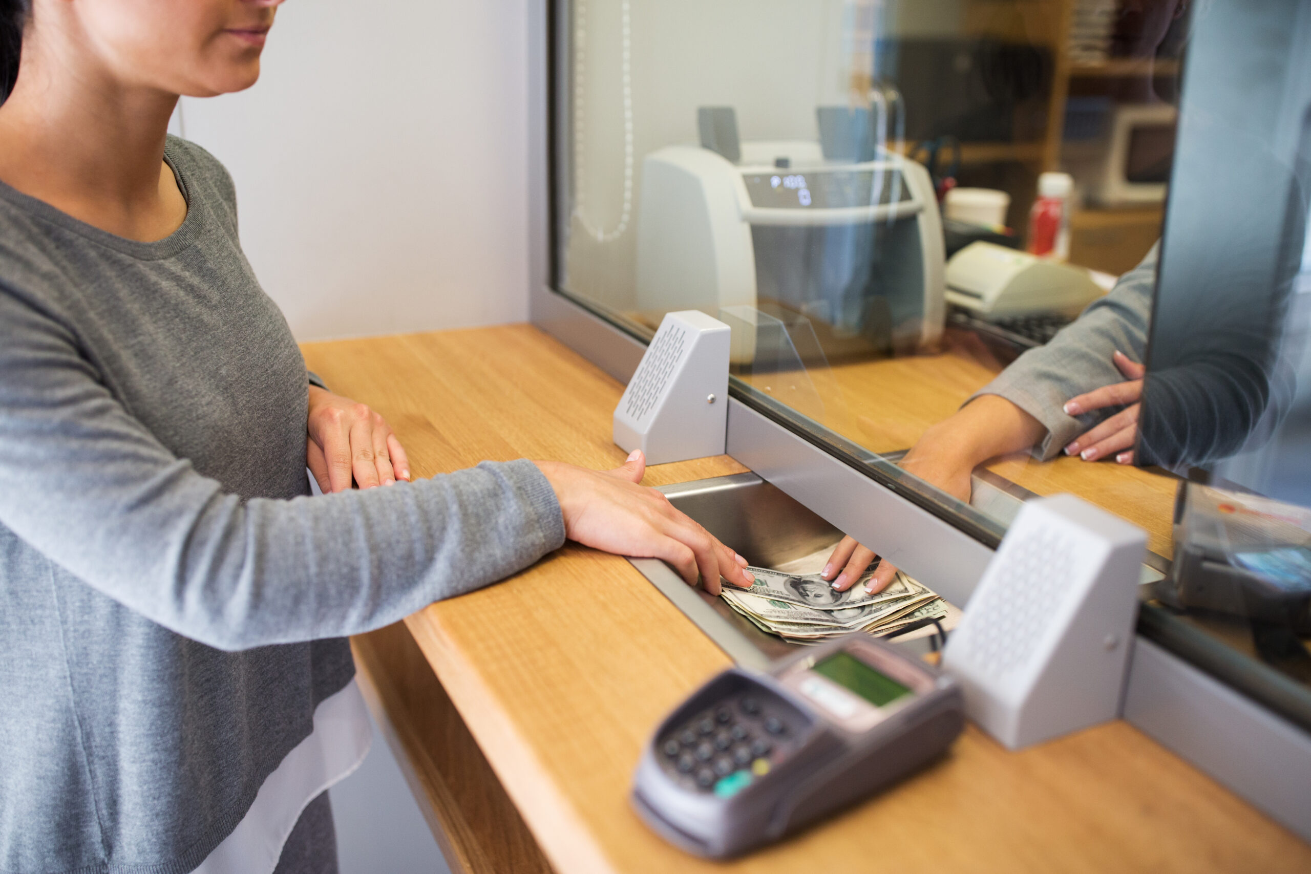 A customer depositing cash with a bank teller