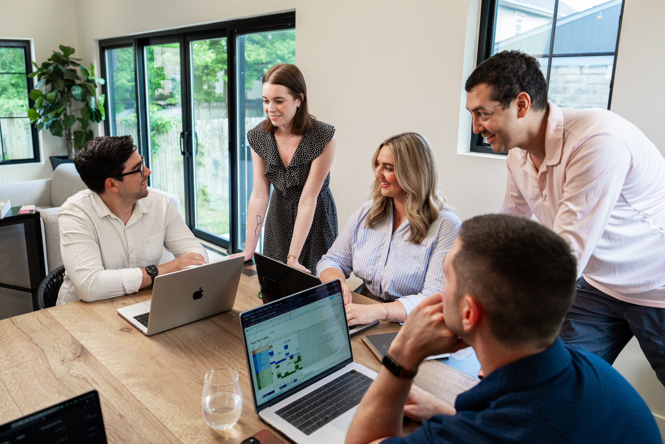 A team collaborating around a laptop discussing software